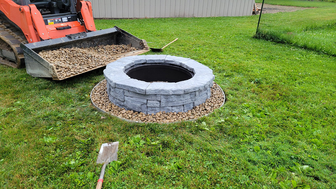 Custom flagstone fire pit patio with boulder retaining wall on Michigan lakefront property