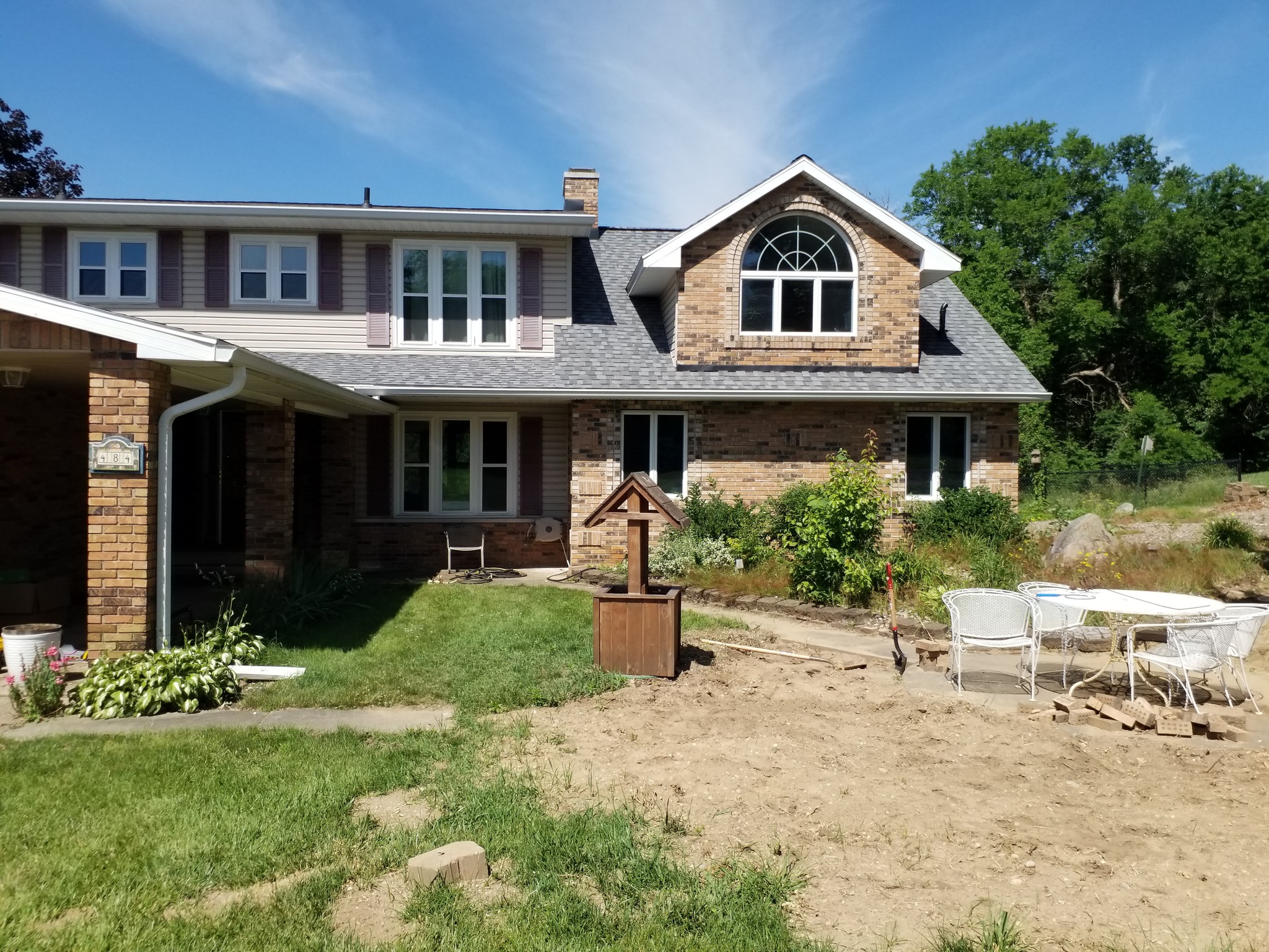 Before front yard renovation with bare dirt and overgrown beds