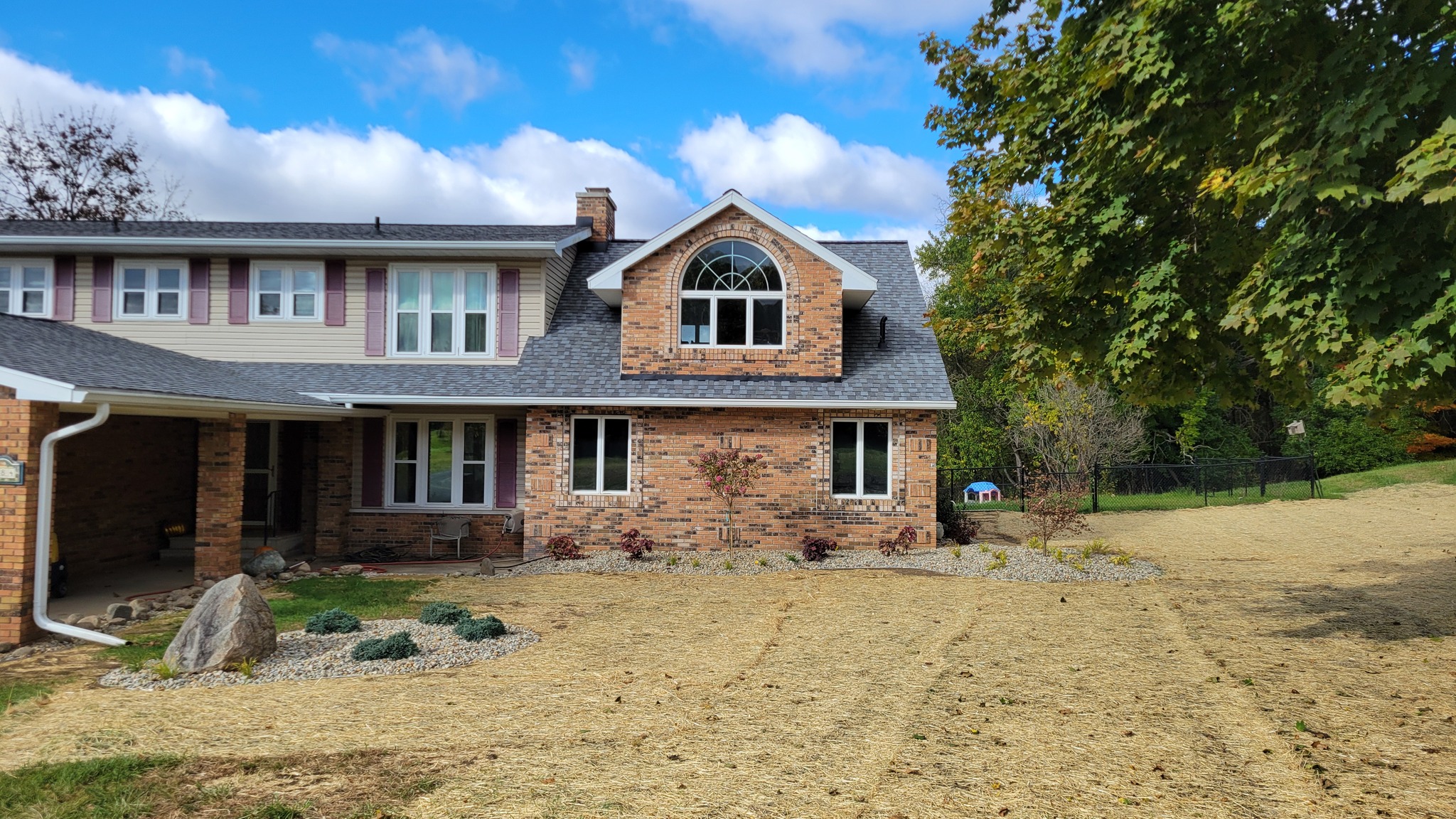 After front yard renovation with boulder feature, river rock beds and Japanese maples